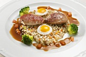 Quail breasts on pearl barley with quails' eggs & bacon sauce