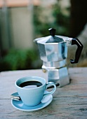 A cup of espresso and espresso pot