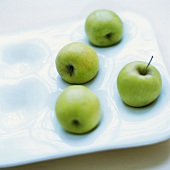 Green apples in a white dish