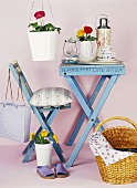 Blue table with crockery, chair, basket and flowers