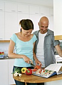 Frau und Mann bereiten dass Essen gemeinsam zu
