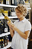 Frau kauft Wein im Supermarkt