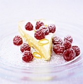 Piece of lemon pie with raspberries and icing sugar