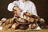 Baker with various loaves of bread