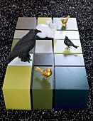 Rechteckiger, mehrfarbiger Wohnzimmertisch mit Tierfiguren auf schwarz-weißem Teppich
