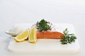 Raw salmon with dill and lemon wedges