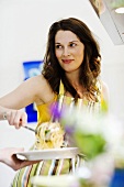 Young woman serving spaghetti