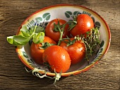 Tomatoes, basil and thyme in rustic metal dish