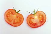 Two slices of tomato with calyxes