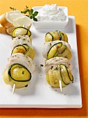Courgettes, potatoes and fish on skewers, with herb quark