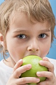 Little boy biting into an apple