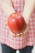 Kind hält roten Apfel