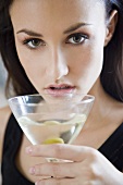 Junge Frau trinkt ein Glas Martini