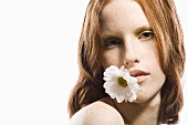 Red-headed woman holding a flower in her mouth