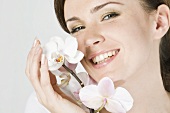 Smiling woman with white orchid