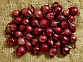 Red onions on jute (overhead view)