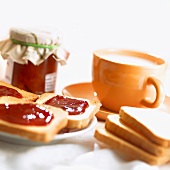 Toastbrote mit Erdbeermarmelade und Tasse Milch
