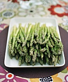 Green asparagus on white serving platter