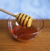 Honey in glass dish with honey dipper
