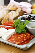 Plate of antipasti: sliced sausage, cheese and olives etc.