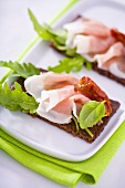 Raw ham, rocket and dried tomatoes on wholemeal bread