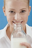 Young woman drinking milk out of the bottle