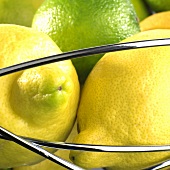 Lemons and limes in wire basket (close-up)
