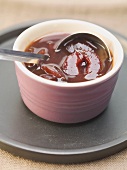 Spiced plum sauce in dish with ladle
