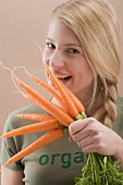 Woman biting a fresh carrot