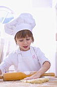 Girl in chef's hat rolling out pastry