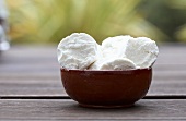 Goat's cheese in bowl on wooden table