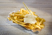 Chips with mayonnaise and plastic fork on paper plate