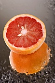 Half a pink grapefruit on wet mirror