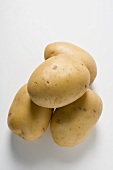 Four Potatoes Stacked on a Weathered Table