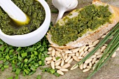 Chive pesto on bread, surrounded by ingredients