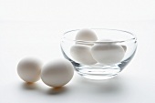 weiße Eier in und neben einem Glasschälchen