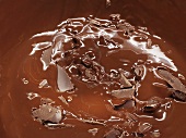 Geschmolzene Schokolade mit Schokostücken (bildfüllend)