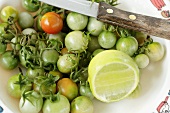 Green baby tomatoes with lemon and knife