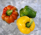 Yellow, red and green peppers on ice