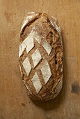 A rustic loaf of bread on a wooden background