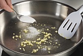 Garlic in a frying pan, adding sugar