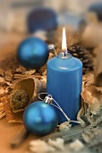 Blue candle with Christmas baubles