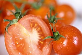 Mehrere reife, frisch gewaschene Tomaten, zum Teil halbiert