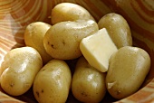 New potatoes cooked in their skins with butter in a dish