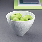 Three apples in a ceramic bowl