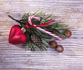 Pine sprig with Christmas decoration on a wooden surface