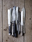 Assorted knives on a wood background