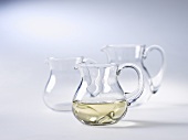 A small jug of white wine and two empty jugs