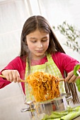 Girl mixing spaghetti with Bolognese sauce