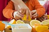 Kinder pressen Zitrusfrüchte aus (für Saft)